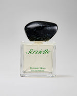 Perfume bottle labeled 'Serviette Byronic Hero' on a light gray background