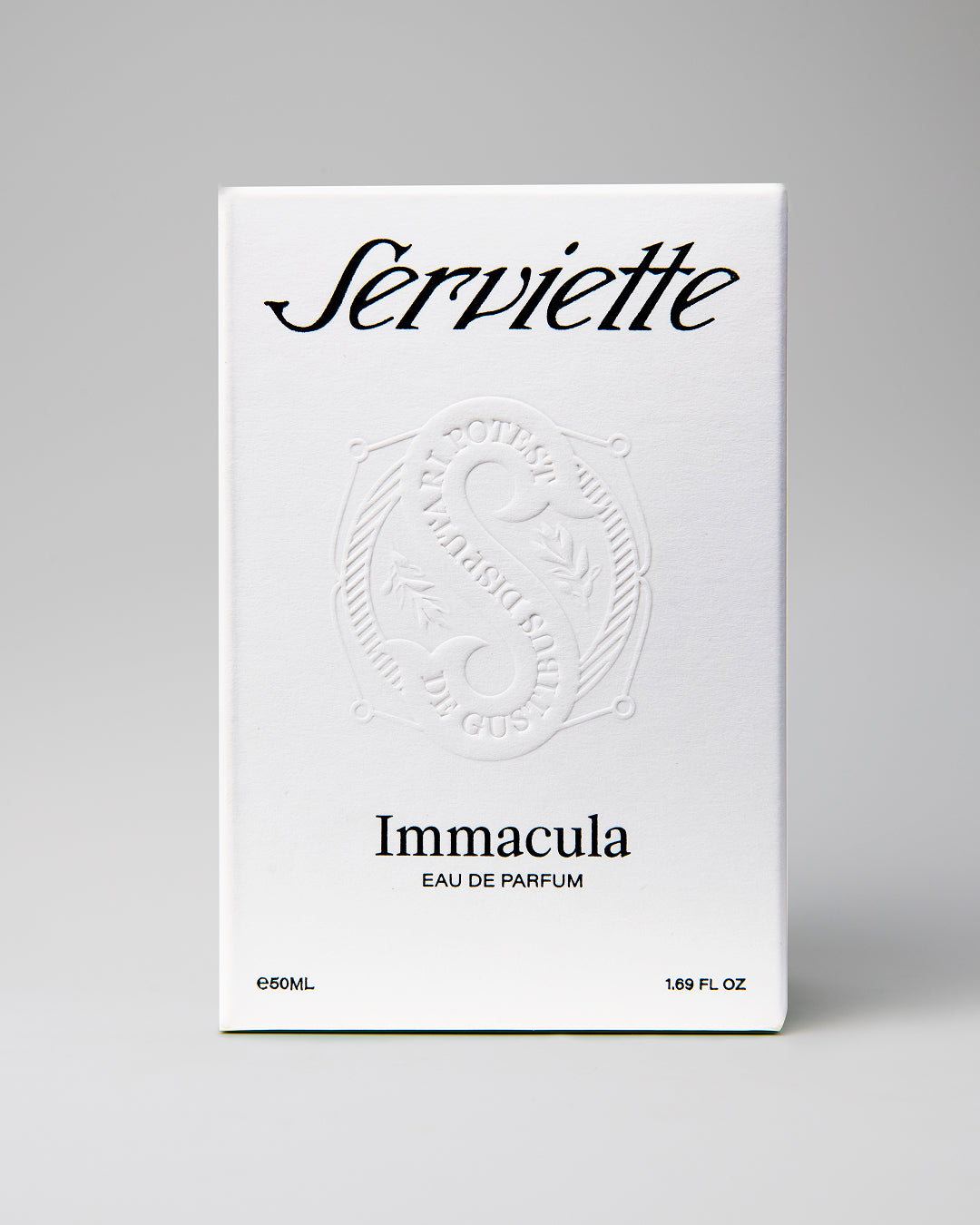 A white rectangular box for Serviette Immacula Eau de Parfum, photographed against a neutral light gray background. The box features black text and an embossed circular emblem in the center.