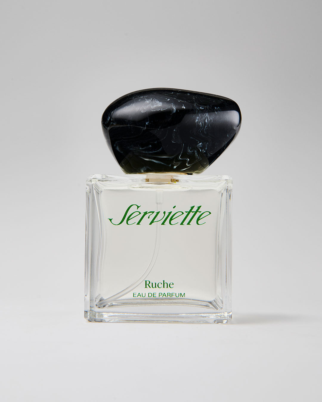 Perfume bottle with black cap and clear glass body on a white background